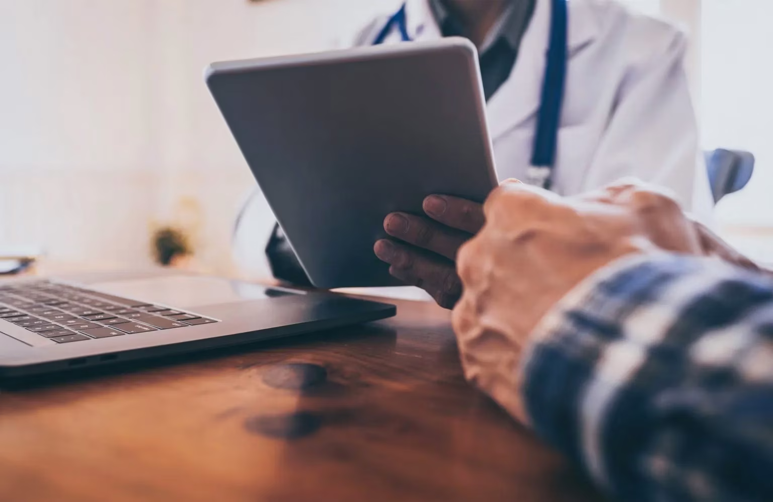Health care provider looking at their tablet and talking to a client