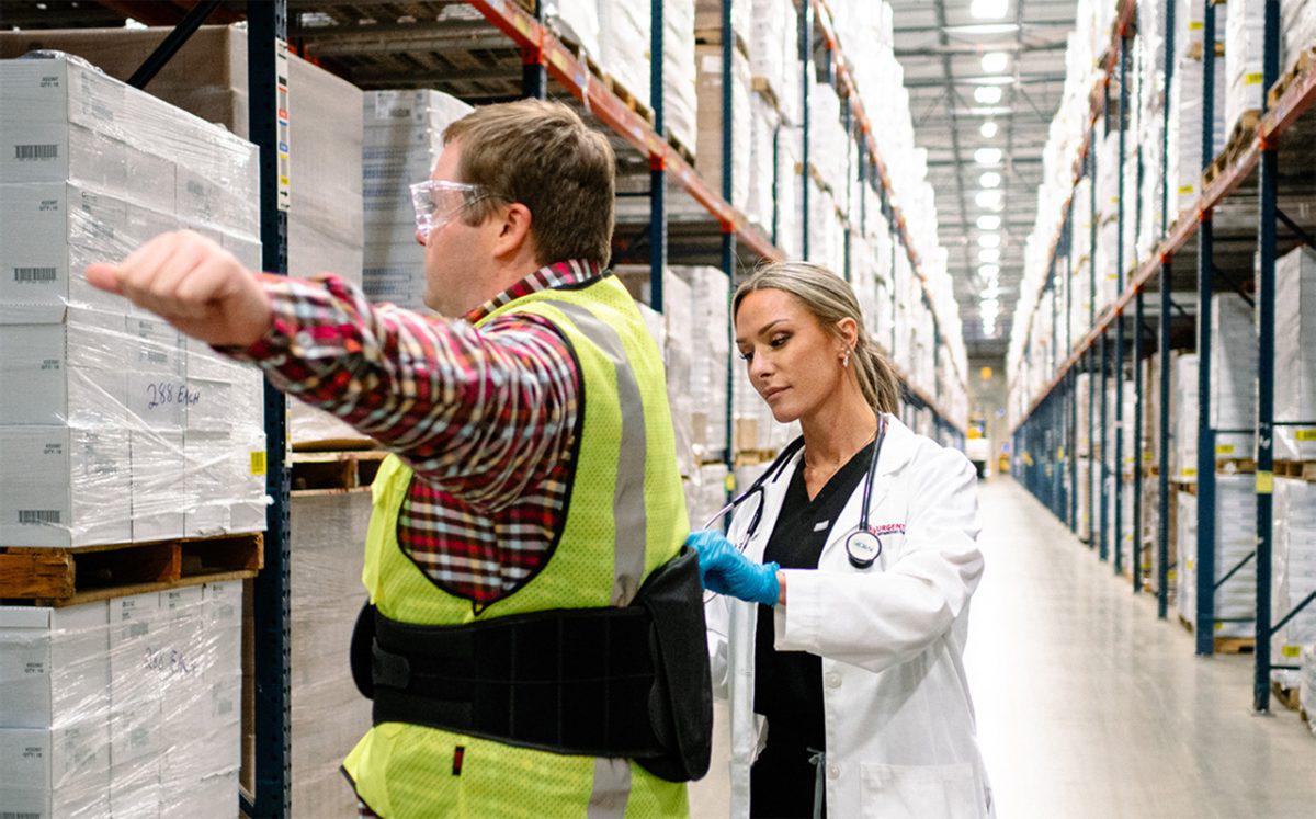 medical provider fitting an employee for a back brace