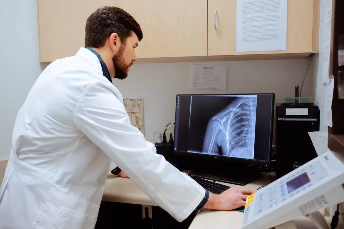 AFC medical professional looking at a front shoulder joint digital x-ray of a patient at the AFC Urgent Care clinic.