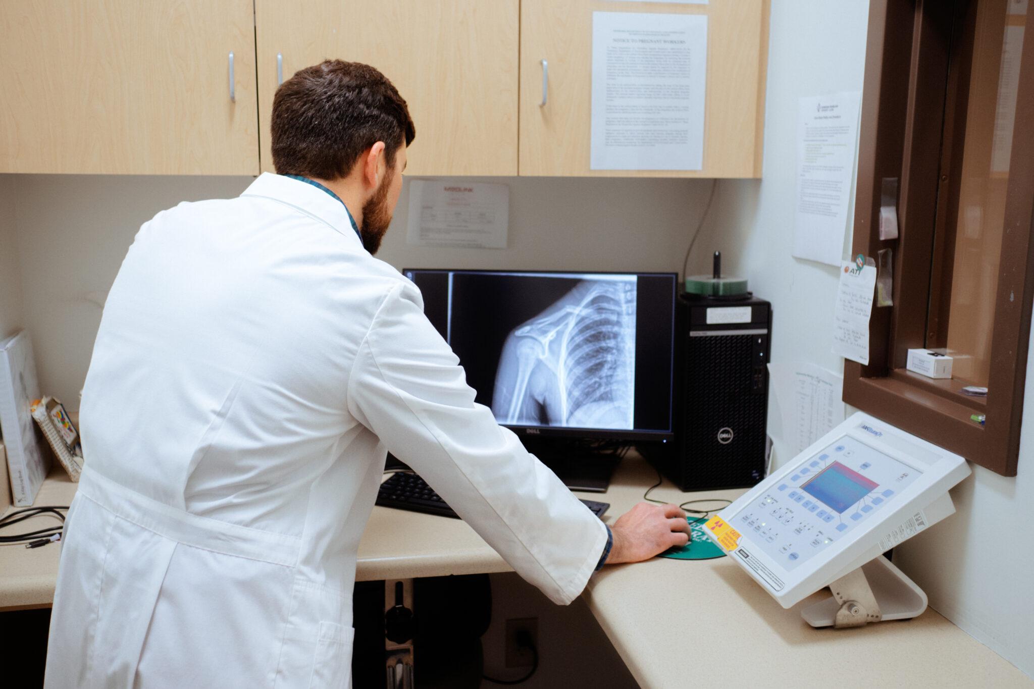 AFC healthcare provider examining a digital x-ray of a patient&rsquo;s chest, left shoulder joint, and left upper arm. 