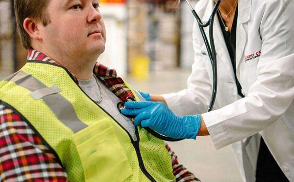 AFC provider listening to a worker's heart during a DOT physical