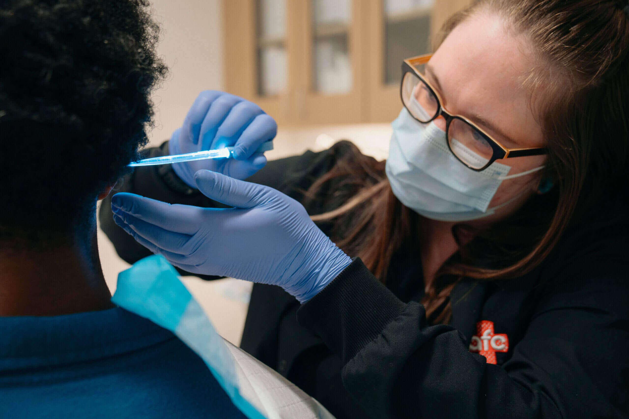 Person receiving ear cleaning at an urgent care