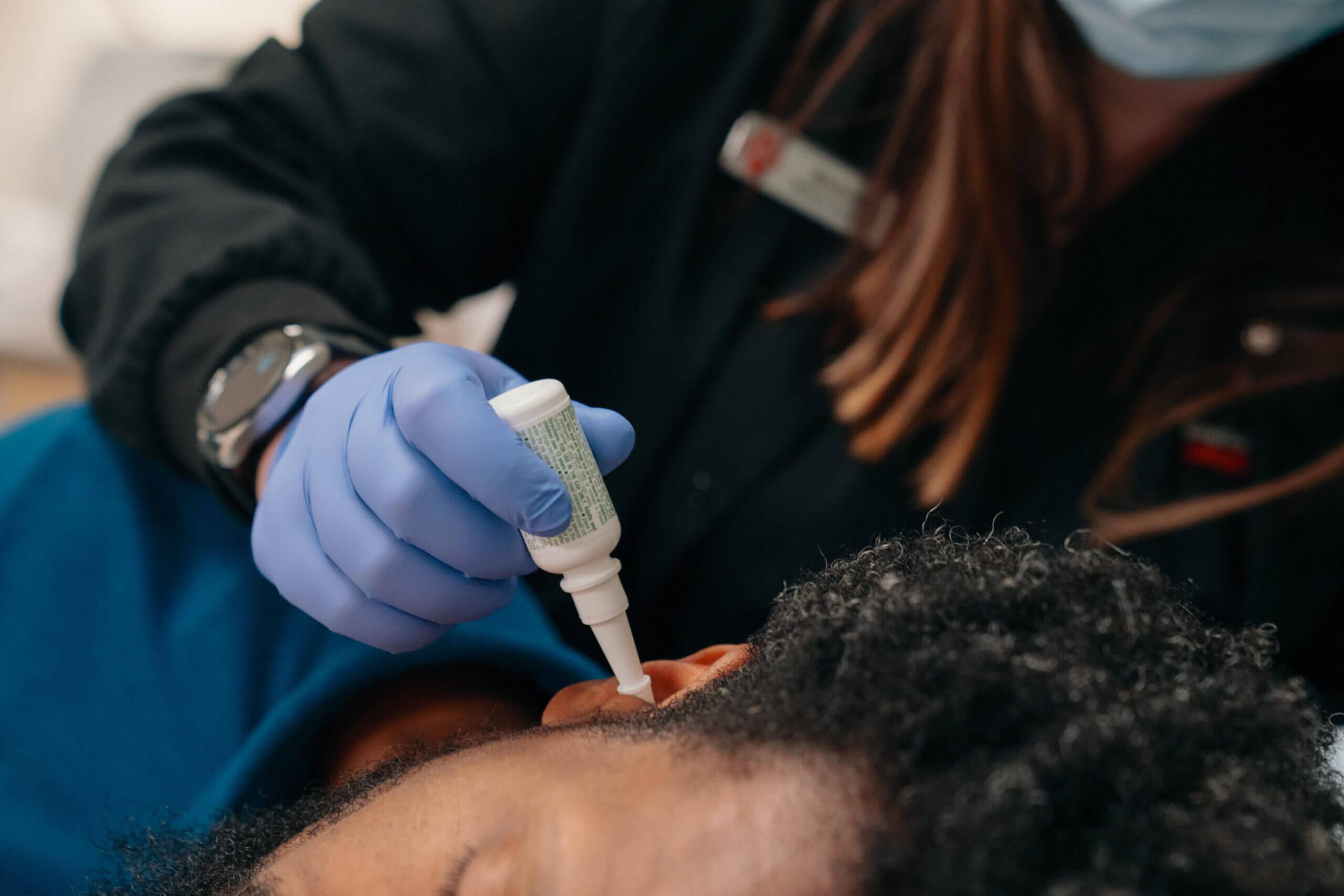 Man receiving ear treatment at an AFC Urgent Care clinic.