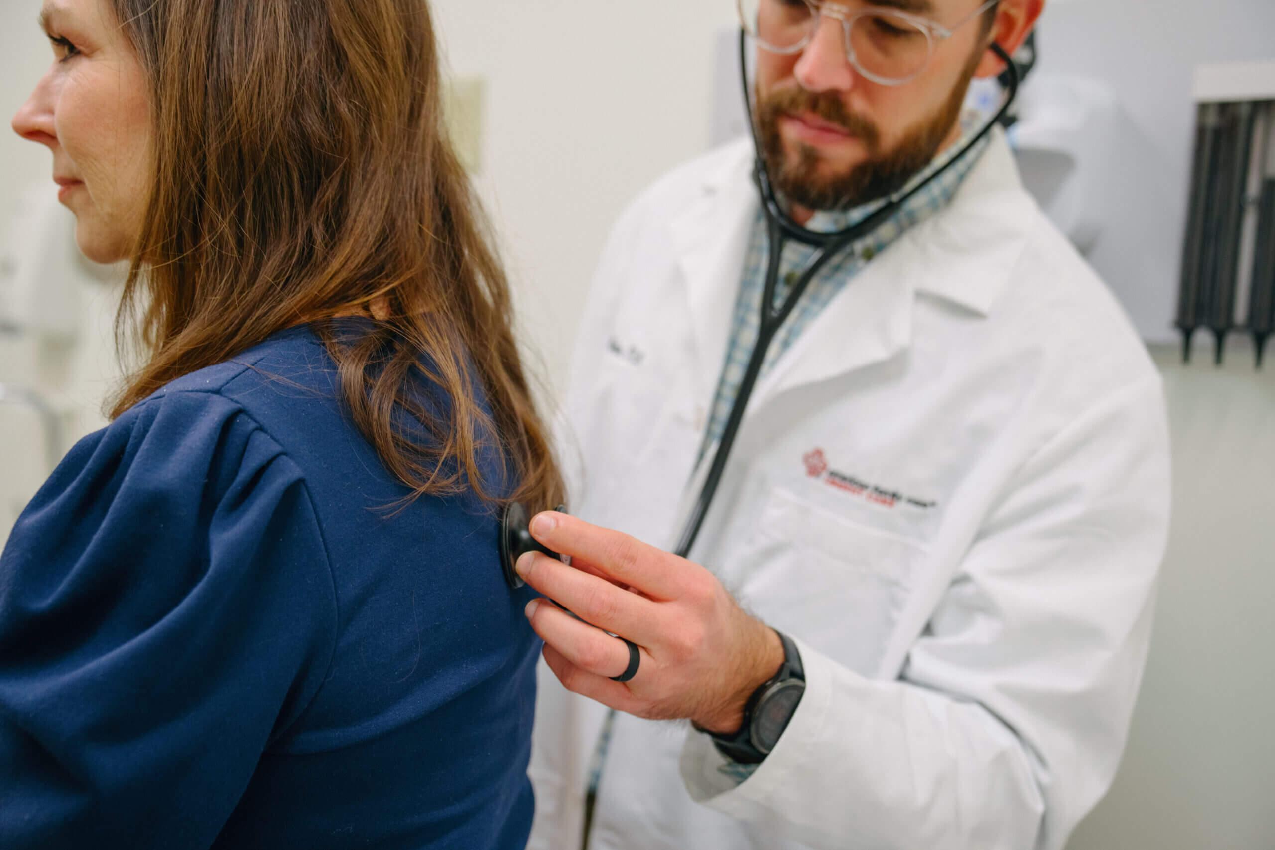 Health care provider checks woman for pneumonia.