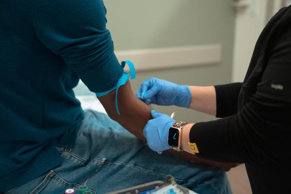 Provider drawing blood from a patient's arm for lab testing
