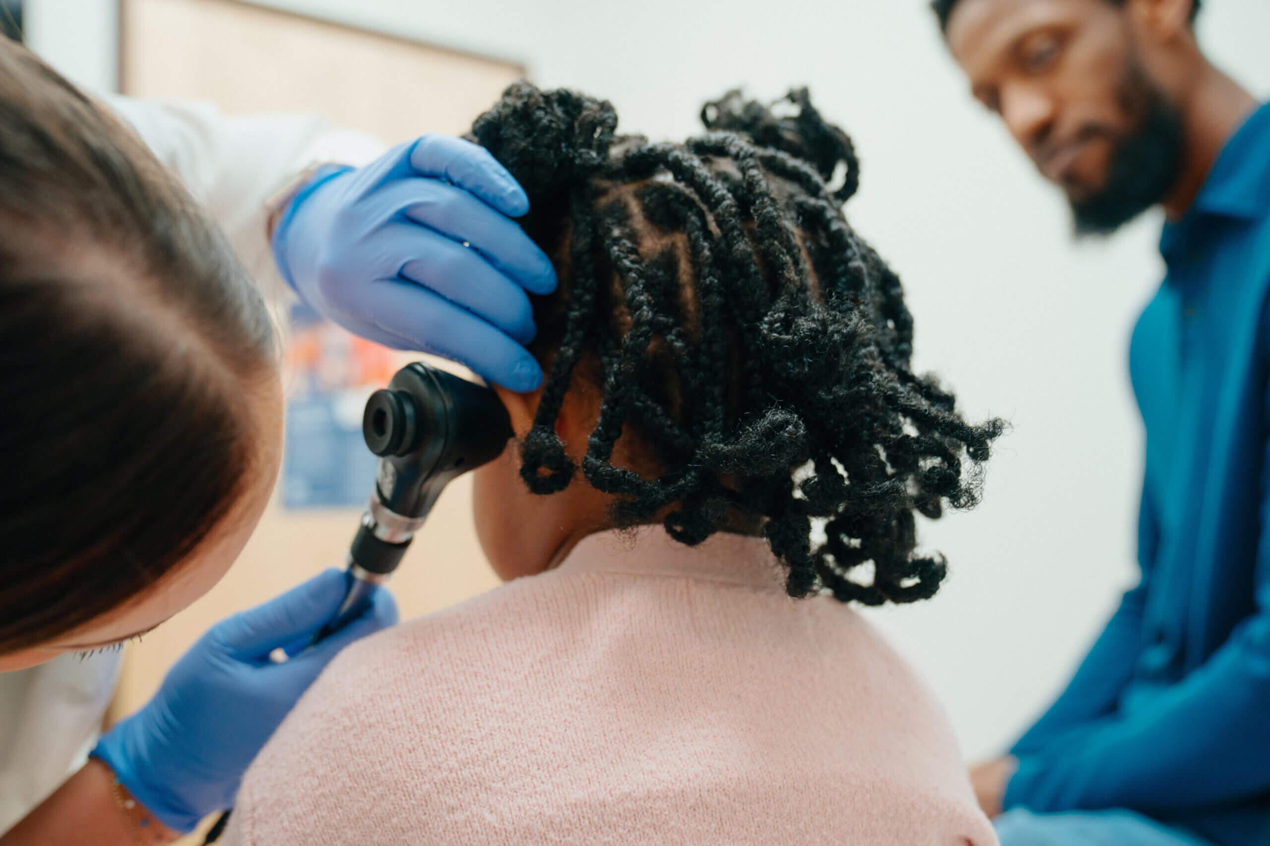 Little girl receiving ear check at an AFC Urgent Care clinic