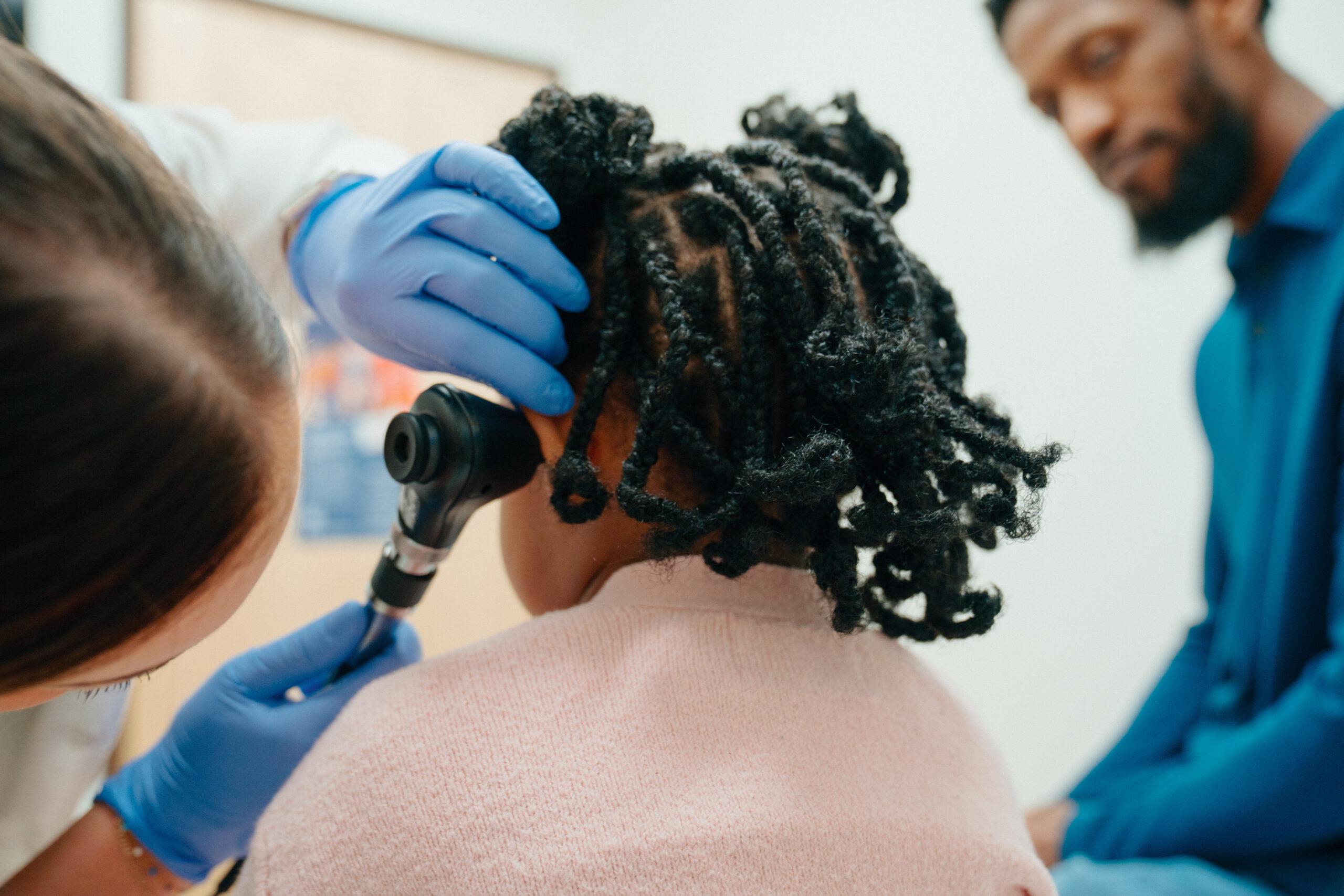 Little girl receiving ear check at an AFC Urgent Care clinic