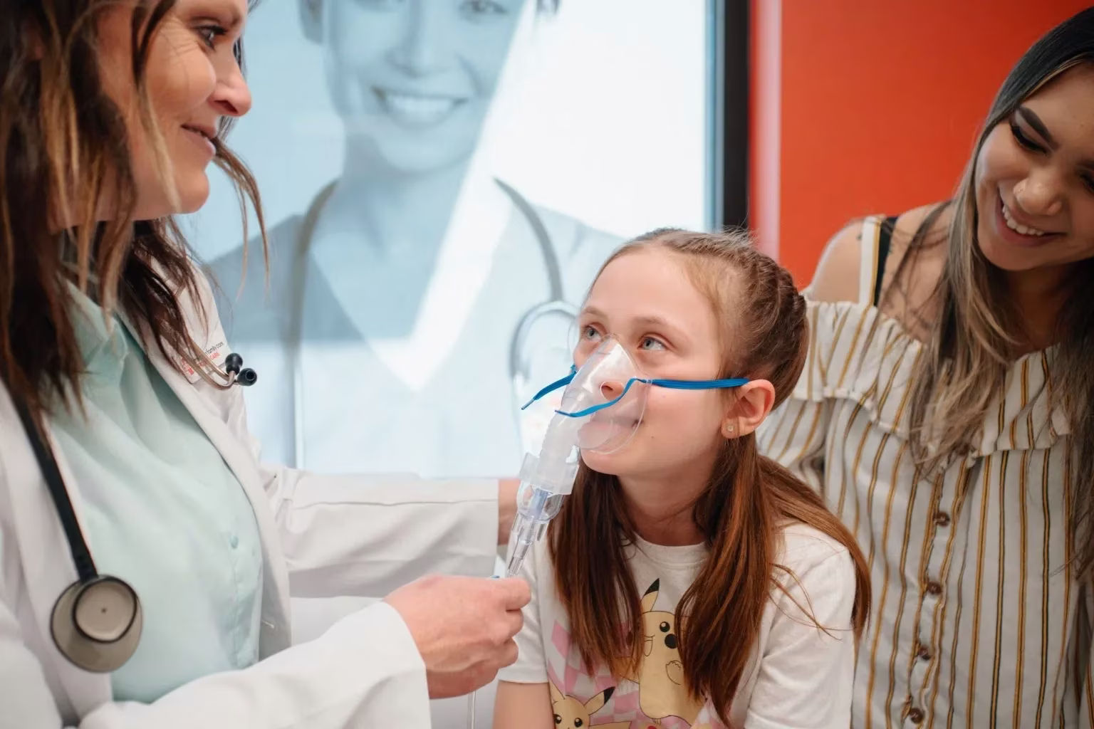 Little girl wearing an oxygen mask talks to AFC physician
