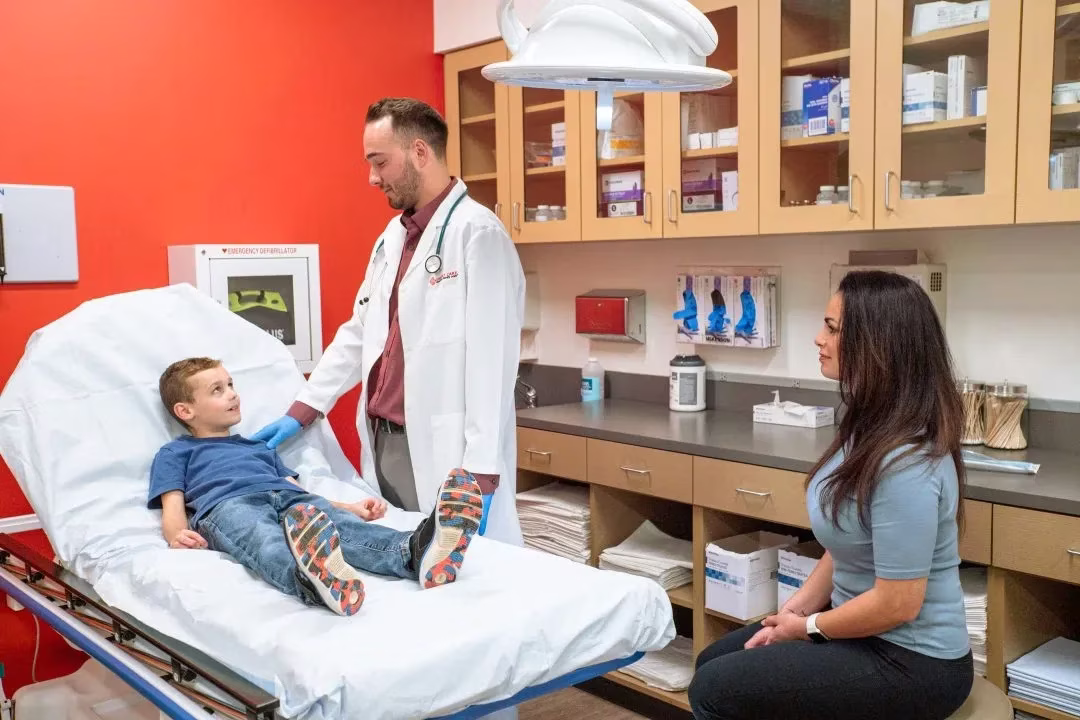 AFC provider talking to a young boy about his sick visit while mother sits on the side