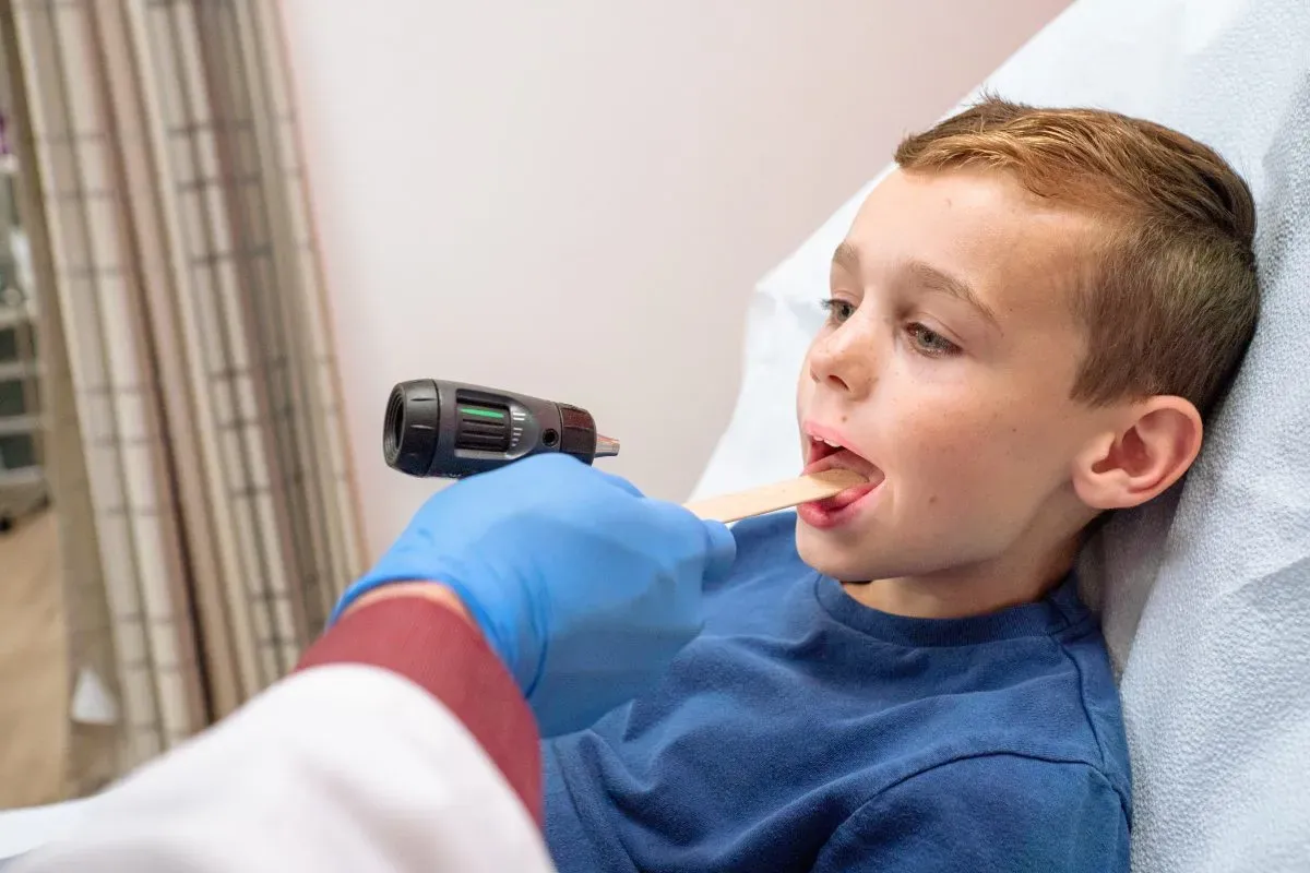Young boy gets his throat checked for Strep Throat by a medial professional at AFC