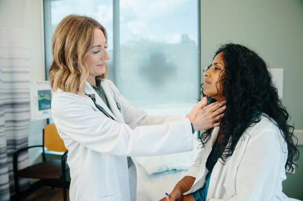 AFC provider examining a patient's neck during a physical exam