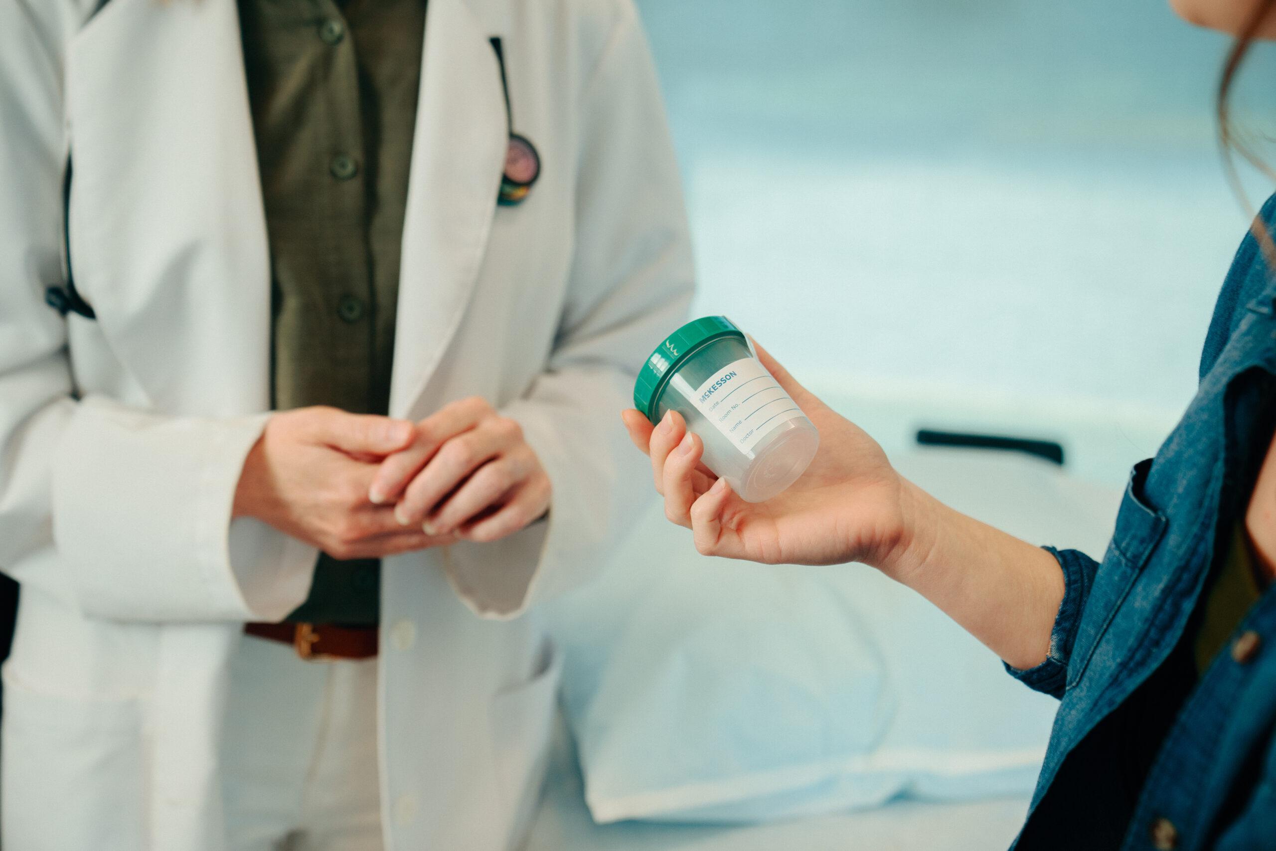 AFC patient holds urine sample cup