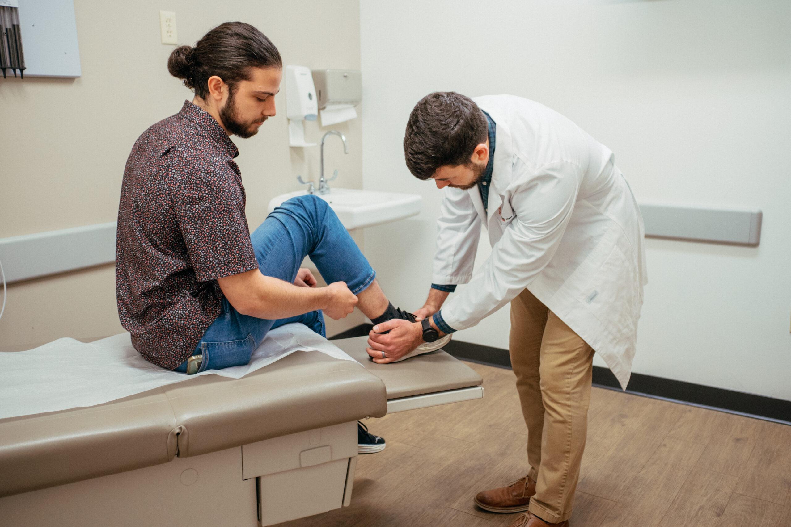 AFC healthcare provider preparing to evaluate a patient&rsquo;s foot for athlete&rsquo;s foot symptoms.