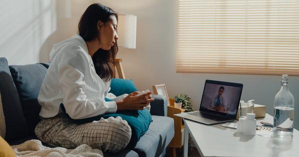 Woman at home on a video visit with a provider on her laptop
