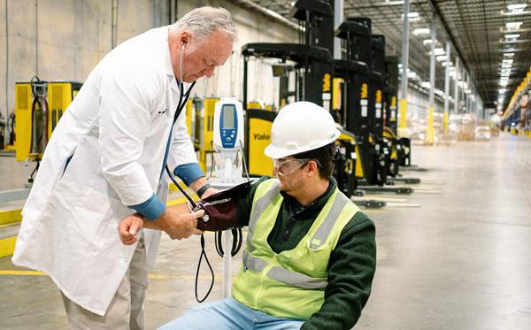 AFC provider checking a warehouse employee's blood pressure