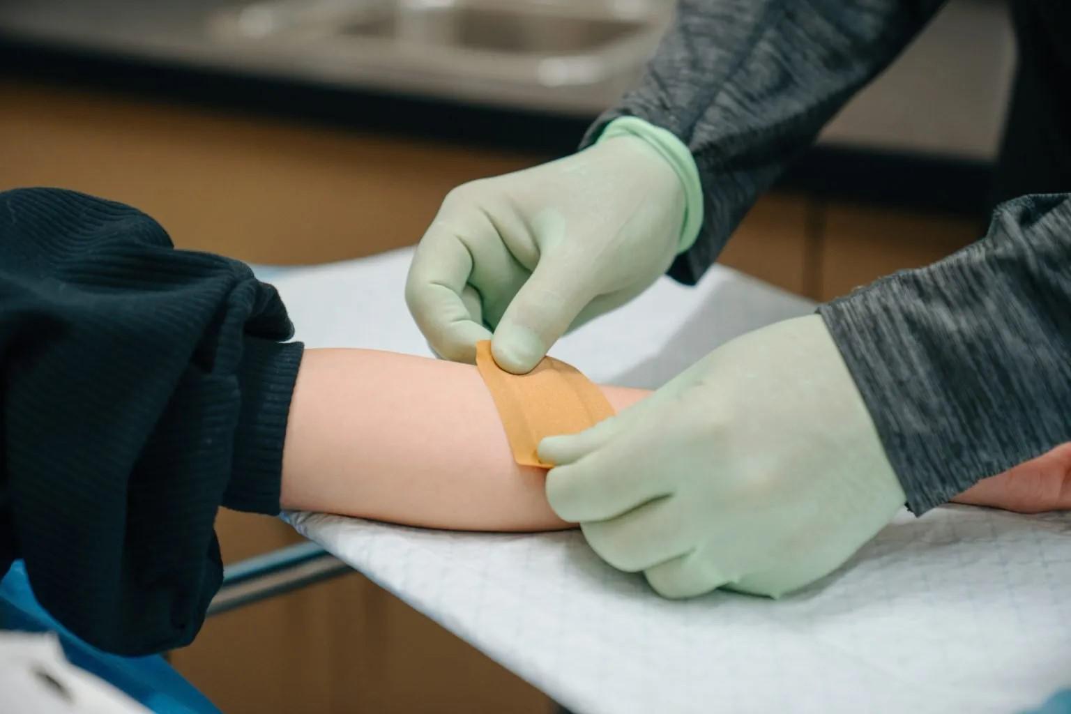 Provider bandaging patient's arm after cyst treatmentProvider bandaging patient's arm after cyst treatment Provider bandaging patient's arm after cyst treatmentProvider bandaging patient's arm after cyst treatment