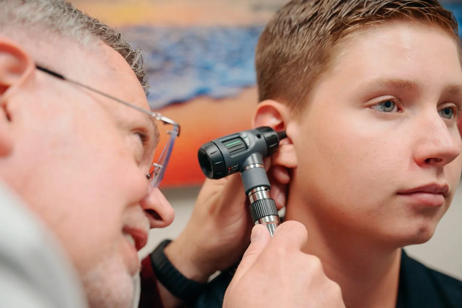 Medical provider examining patient's ear for an ear infection at AFC Fort Collins Medical provider examining patient's ear for an ear infection at AFC Fort Collins