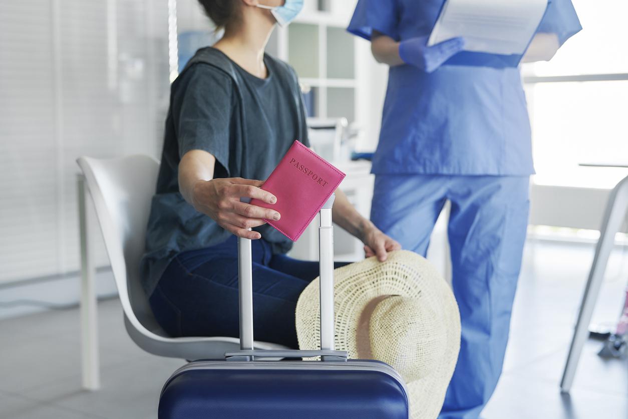 Patient holding a passport while an AFC staff member reviews immigration documents