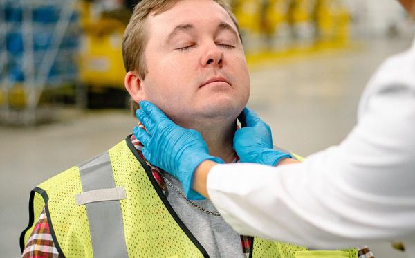 AFC provider examining a worker's neck during an employment physical