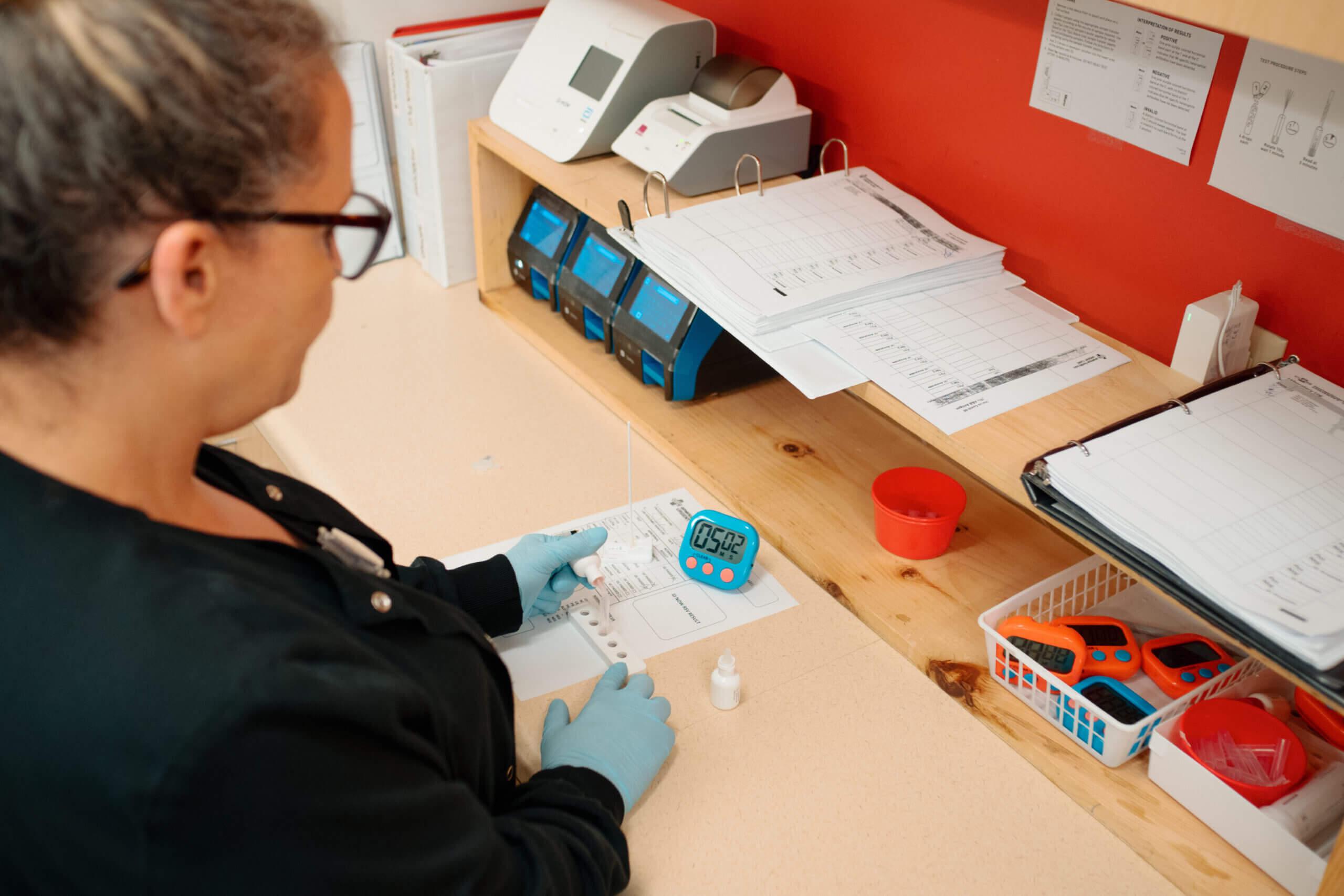 Female AFC technician charting lab results given on-site at an AFC urgent care clinic location.