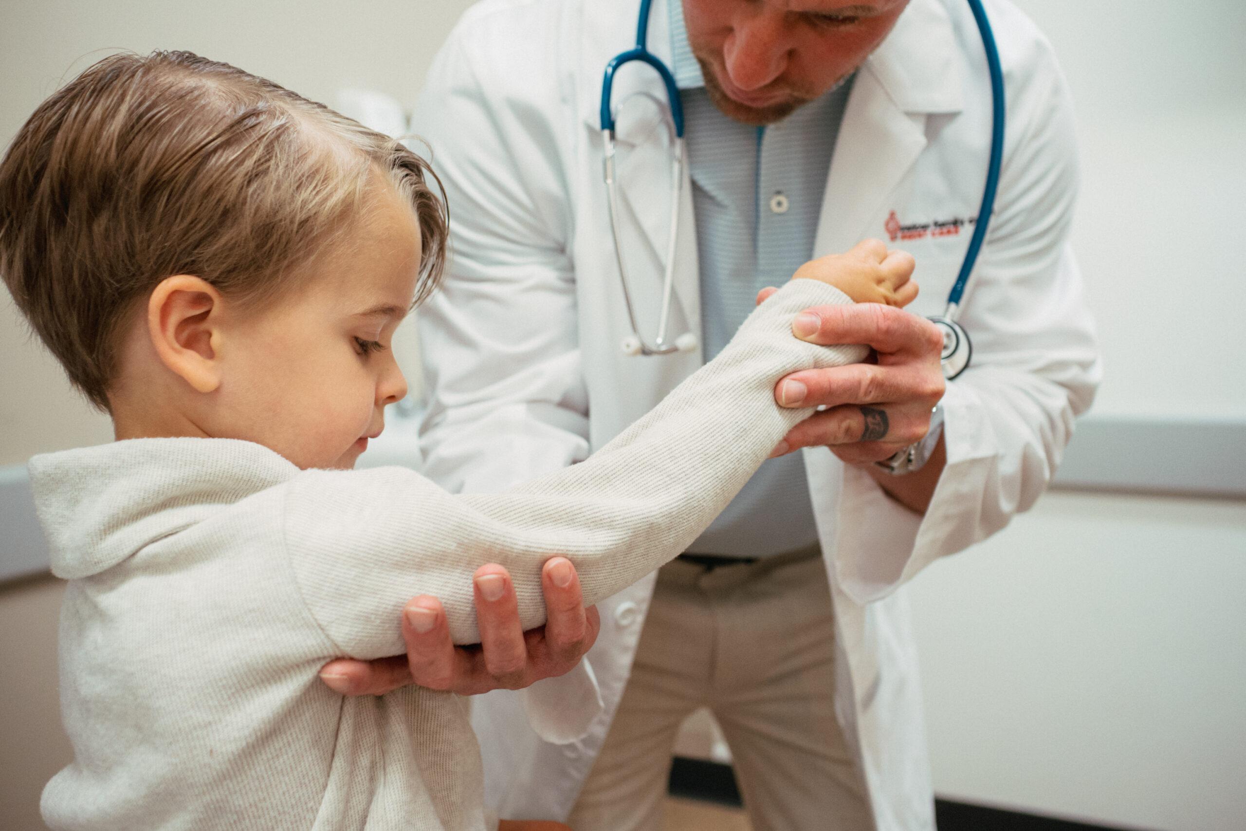 Young child receiving a pediatric exam from an AFC healthcare provider in a comfortable urgent care setting.