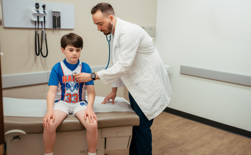Doctor using a stethoscope during a child&rsquo;s sports or school physical