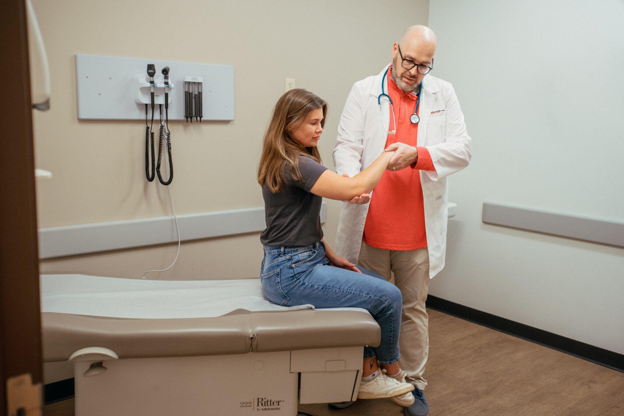 Woman getting arm checked by doctor. 