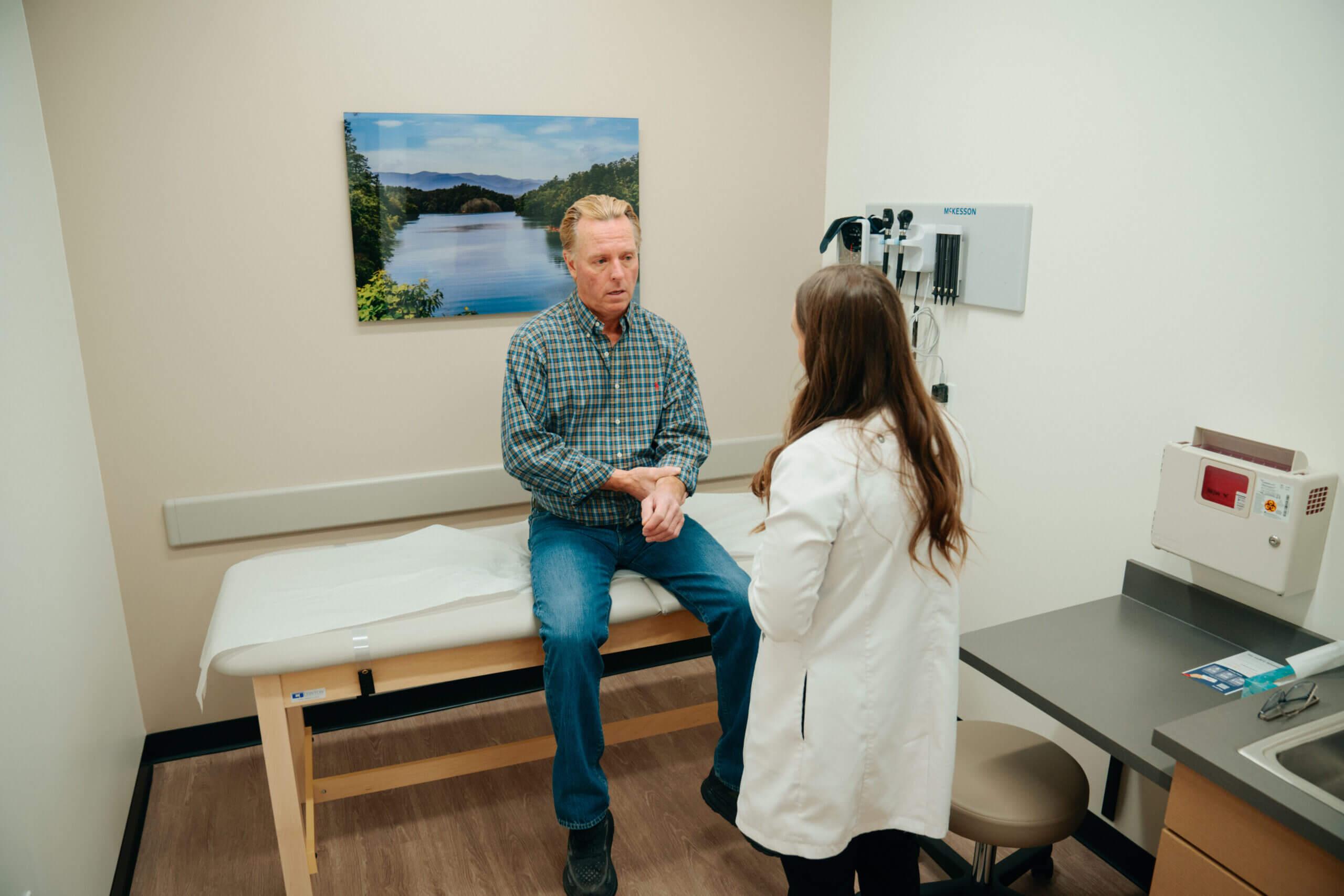 Doctor in a clinic examining a rash on a patient’s forearm